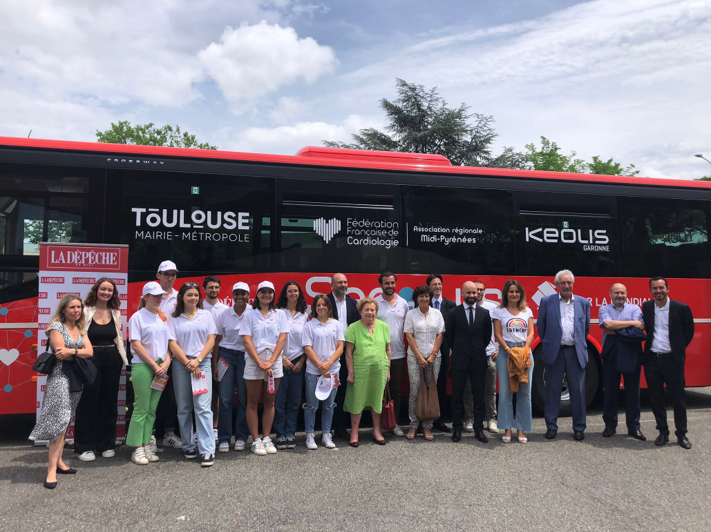 Photo de groupe devant le bus du Secours Tour